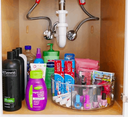 under sink storage with a lazy susan filled with toothpaste and cosmetics