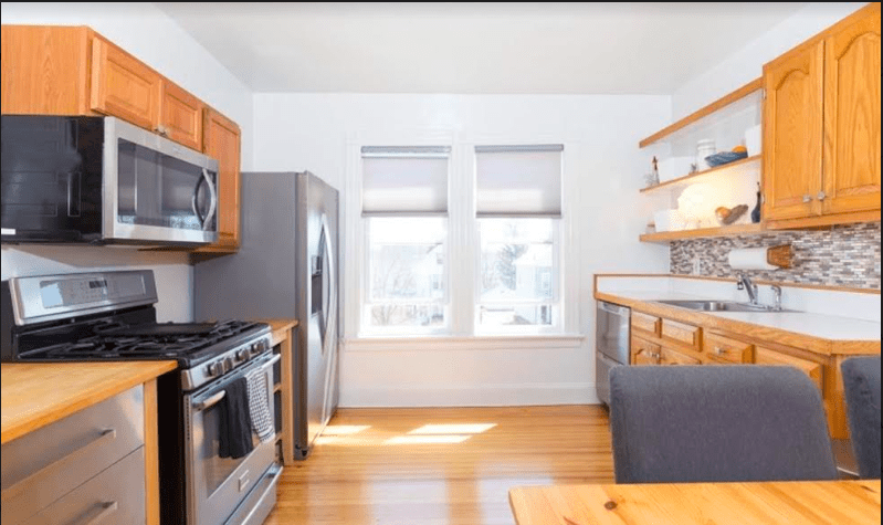 photo of a kitchen with wood cabinets and tile backspace  