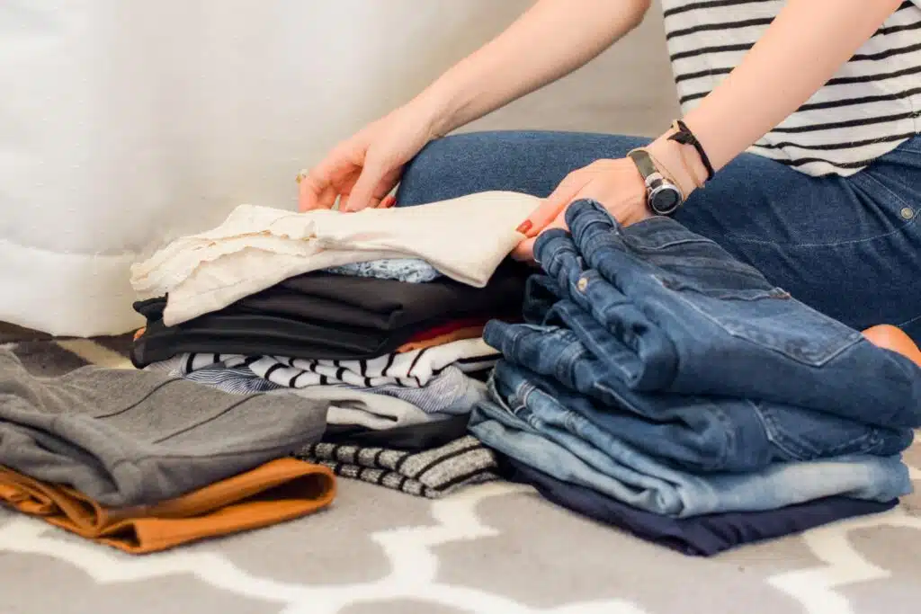 a woman sitting by folded laundry